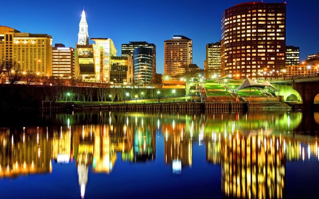 Downtown Hartford Connecticut skyline at night with city lights reflecting on the Connecticut River